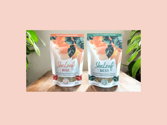 SheLeaf's RISE and REST premium Kratom blended tablets on wooden table with Kratom plants on the right and left side